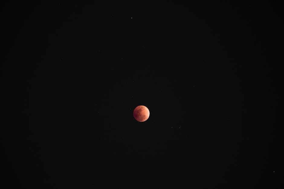 A breathtaking view of the blood moon surrounded by stars during a clear night.